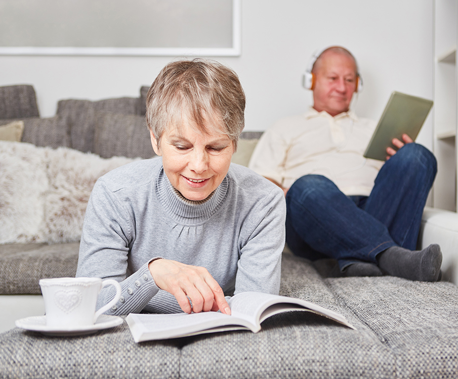 Mann und Frau lesen auf dem Sofa