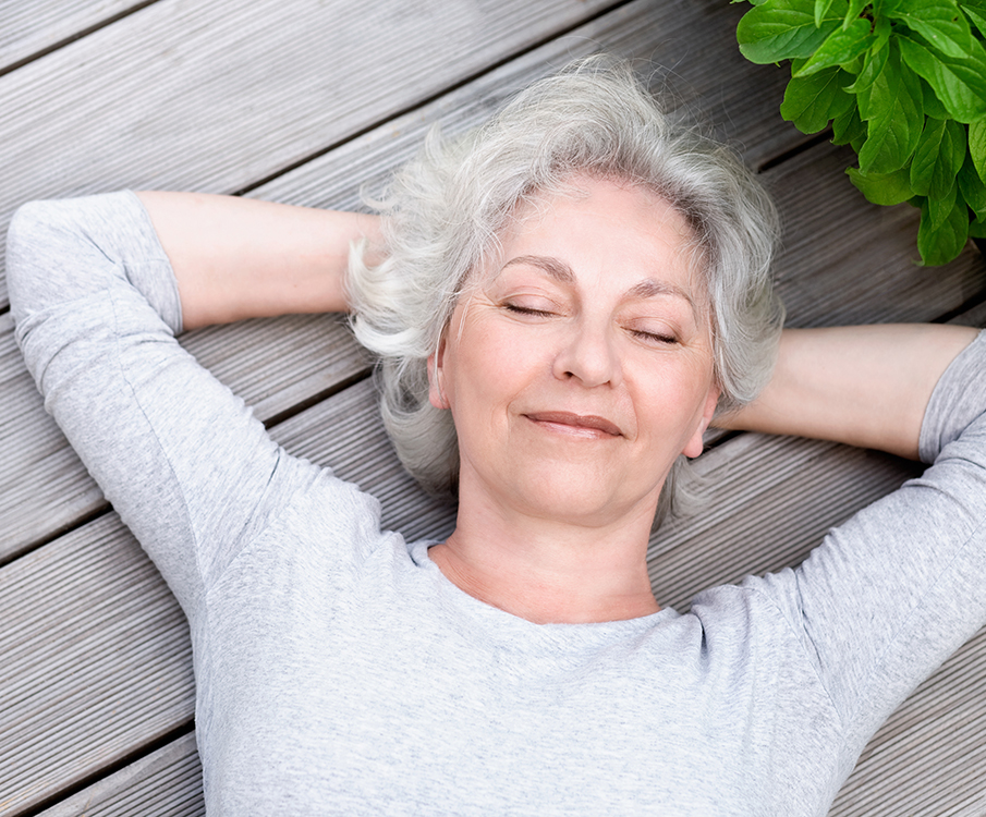 Zufriedene Frau liegend auf Terrasse