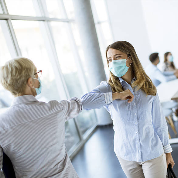begruessung zwei Frauen mit Masken