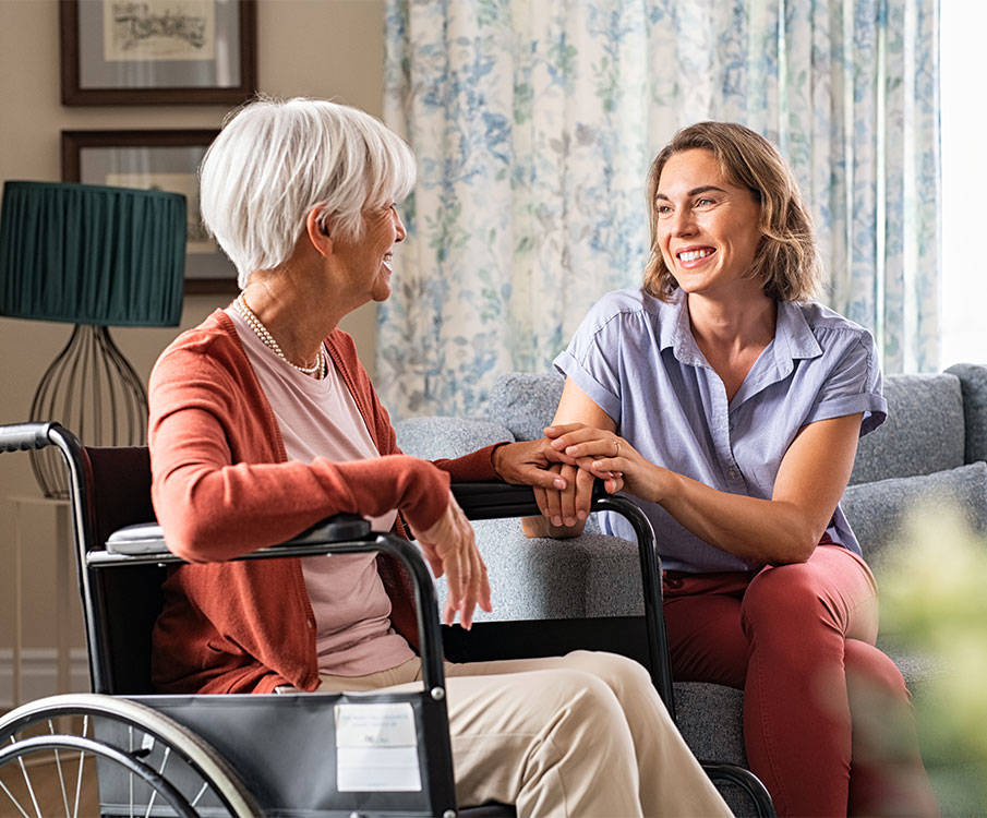 Pflegerin mit Patientin im Rollstuhl