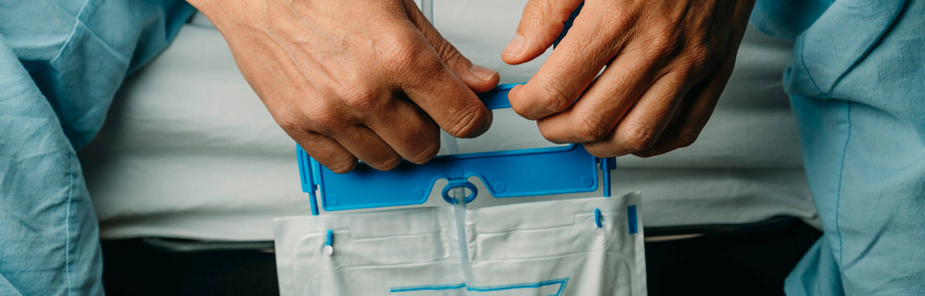 Patient hält Urindrainagebeutel