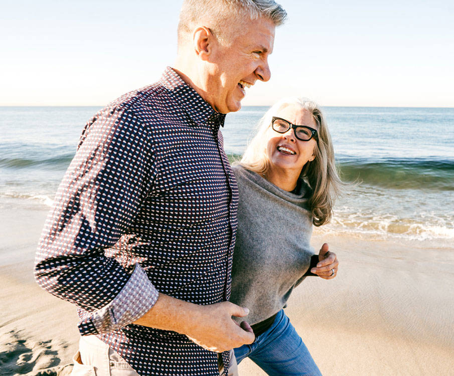 Älteres Paar spaziert am Strand