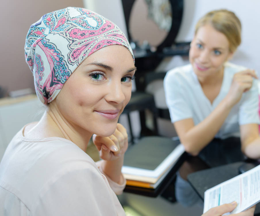 Fachkraft berät onkologische Patientin mit Kopftuch