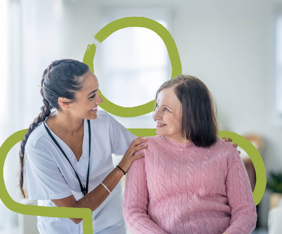 Pflegefachkraft und Patientin lächeln sich an